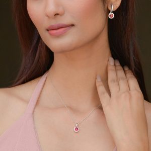 Close-up of a woman wearing elegant pink gemstone jewelry, showcasing a matching necklace and earrings.